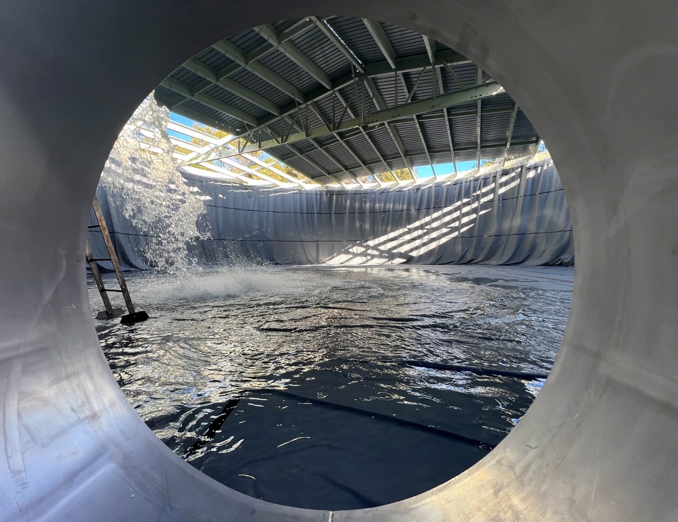 Water tank being refilled with view from round pipe looking into the tank