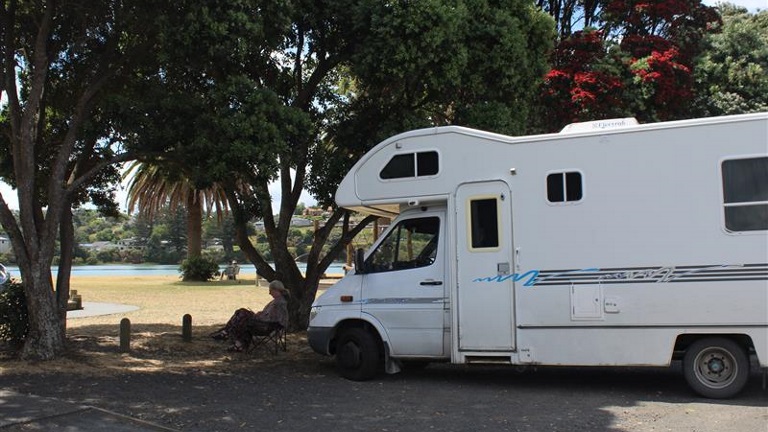 8119a2da-d8ce-4dc9-aeab-9289f26ff16a Camper van parked by beach