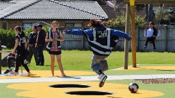 pr-21106-buckland-road-playground-oct-4.tmb--1600-1600 A child leaps from one small in-ground trampoline to another.